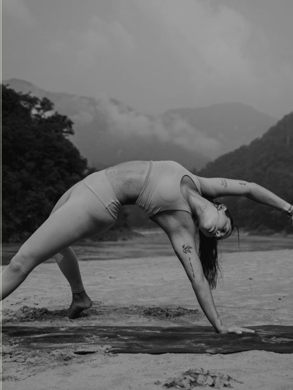 Olivia Mira Cloud holding a yoga backbend beside a river